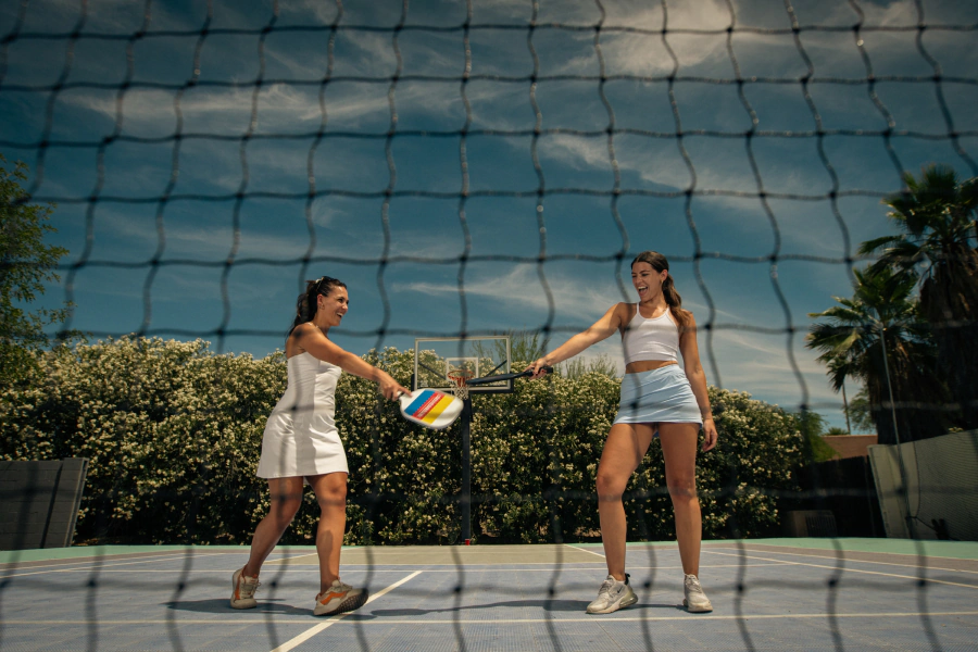 two woman bonding on pickleball court